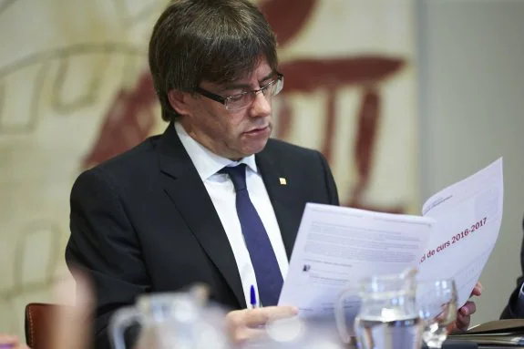 Puigdemont revisa un documento durante la reunión de ayer del Gobierno catalán. :: A. García / efe
