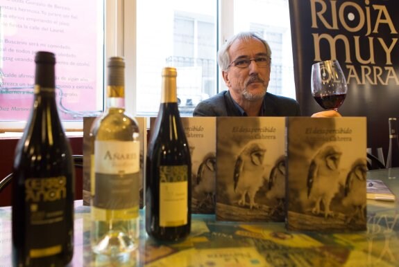 Antonio Cabrera posa en el Café Bretón con su nuevo libro 'El desapercibido' y botellas de Olarra. 