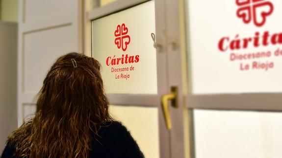 Una mujer ante la entrada de Cáritas.