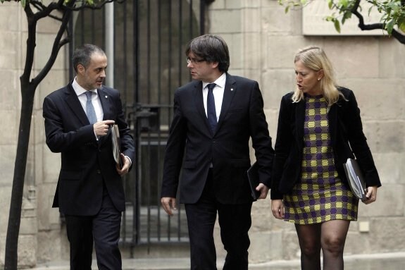 Carles Puigdemont, ayer, junto a la consejera de Presidencia, Neus Munté, y el secretario del Gobierno, Joan Vidal de Ciurana. :: Marta Pérez / efe