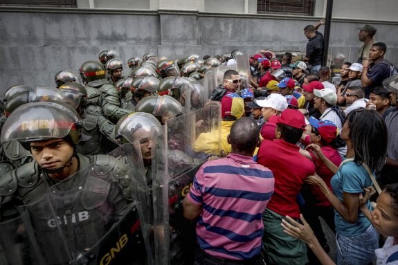 La Guardia Nacional tuvo que parar a los chavistas que aparentemente pretendían asaltar la sede de la Asamblea. :: miguel gutiérrez / efe