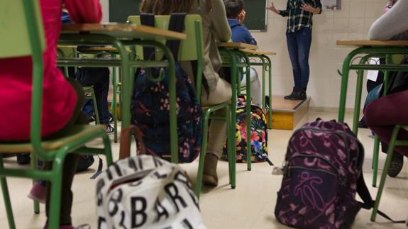 Un grupo de escolares atiende al profesor en clase.