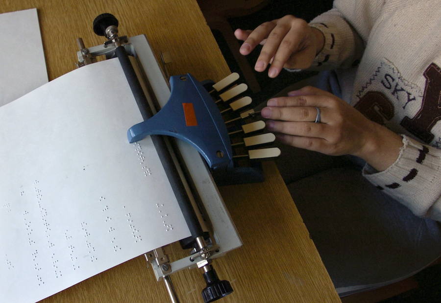 Una estudiante pasa sus apuntes a sistema braille. 