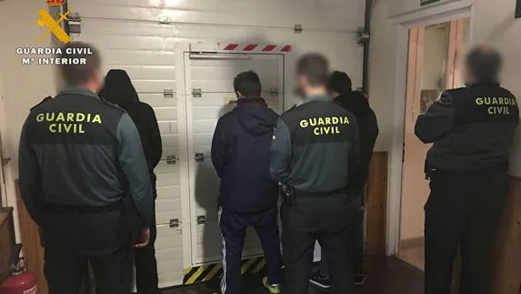 Varios de los detenidos vigilados por agentes de la Guardia Civil. 