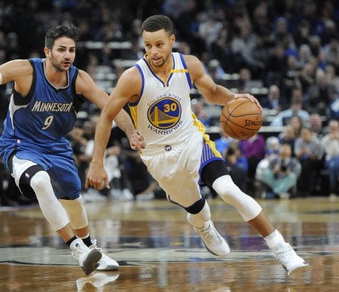 Stephen Curry conduce el balón ante Ricky Rubio. :: efe
