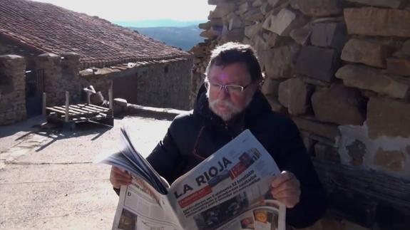 Un vecino lee Diario LA RIOJA a la sombra de una pared. 