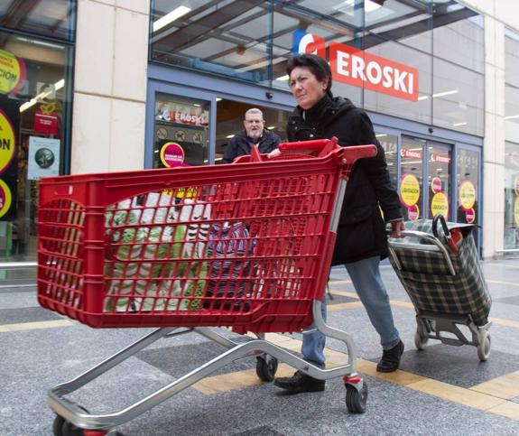 Una mujer empuja un carro de Eroski, junto a la puerta principal del hipermercado del Berceo. :: díaz uriel