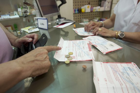 Un pensionista paga parte del valor de los medicamentos en una farmacia de Madrid. :: Isabel B. Permuy