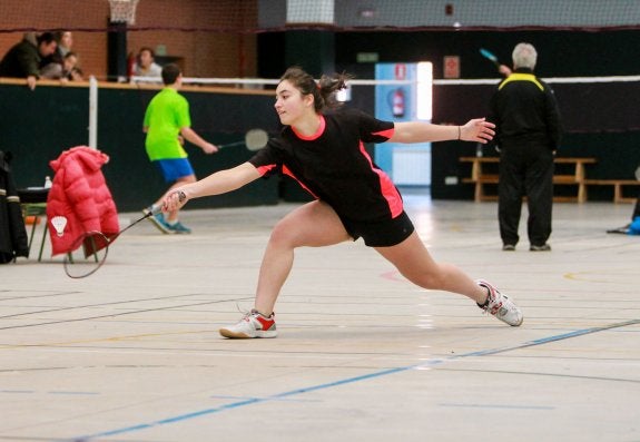 Una jugadora de bádminton se estira para alcanzar el volante. :: F.D.