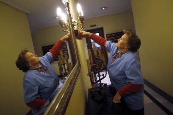 Paquita, de 70 años, limpia el vestíbulo del edificio en el que vive y trabaja. :: susana vera / reuters