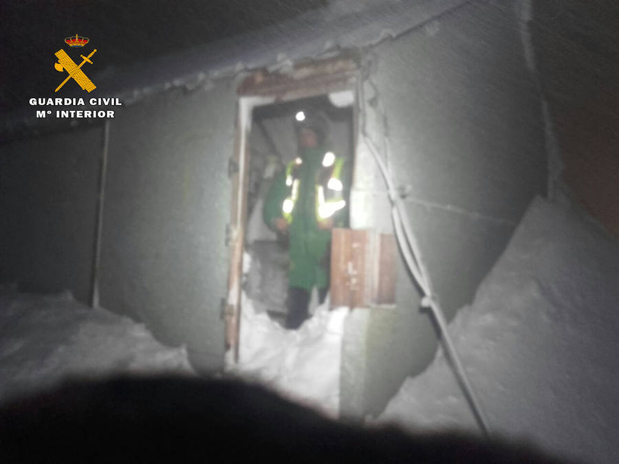 Un agente de la Guardia Civil accede a la caseta donde se refugió el montañero perdido. 