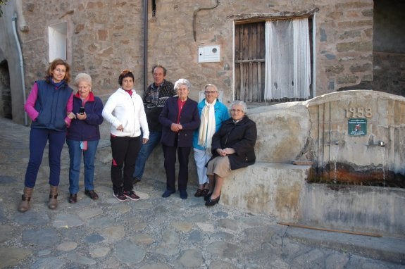 Un grupo de vecinos de Valdeperillo y de Cornago, en la plaza de la fuente de la pedanía.  Una de las mujeres intenta, sin éxito, encontrar cobertura para su teléfono móvil. 