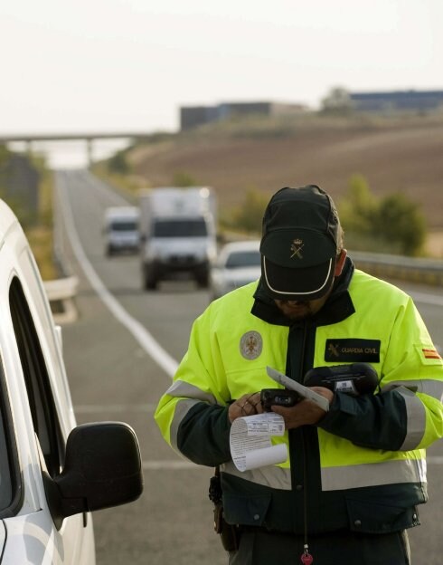 Comprobación. Un agente de la Guardia Civil chequea la documentación de un conductor. :: EFE