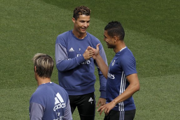 Cristiano Ronaldo choca la mano y bromea con Casemiro durante el último entrenamiento del Real Madrid en Valdebebas. :: chema moya / EFE