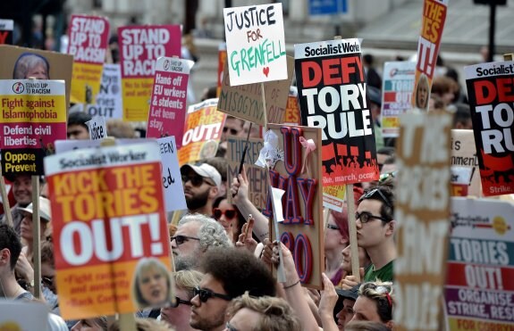 Manifestantes con pancartas pidiendo justicia para las víctimas del incendio de la torre Grenfell. :: CHRIS J. RATCLIFFE / AFP