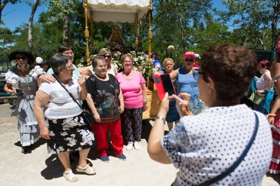 Un grupo de mujeres se fotografía delante del paso con la Virgen del Rocío. :: sonia tercero