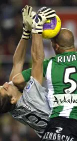 TOMA. Rivas, que luego cayó lesionado, propina un codazo al portero del Sevilla, De Sanctis. / EFE