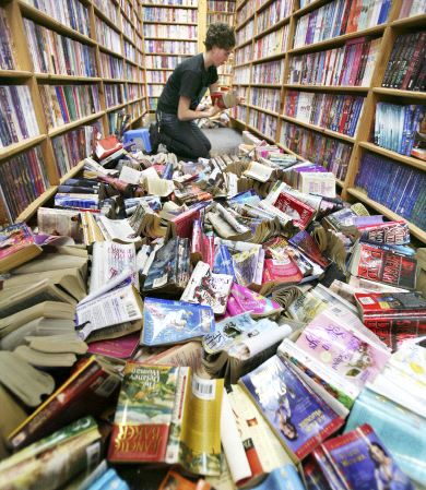 Una mujer recoloca una pila de libros en las estanterías. / AP