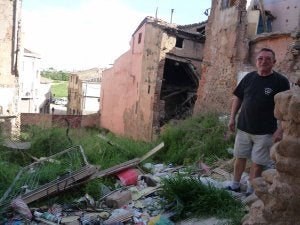 Arriba, estado de las aceras en la Cuesta del Rufo. Abajo, Fernando Peula muestra el estado la casa adosada a su vivienda, en un solar lleno de escombros, de propiedad municipal. ::
I. ÁLVAREZ