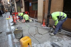 Operarios encargados de 'incrustar' en el adoquinado de la calle Laurel el curso del río Ebro a su paso por La Rioja reproducido en piezas de metal. ::                             JUAN MARÍN