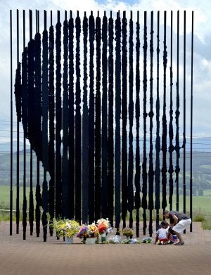 Por todo el país. Una familia deja un ramo de flores en una de las
muchas esculturas que honran a Mandela en Sudáfrica. ::
REUTERS