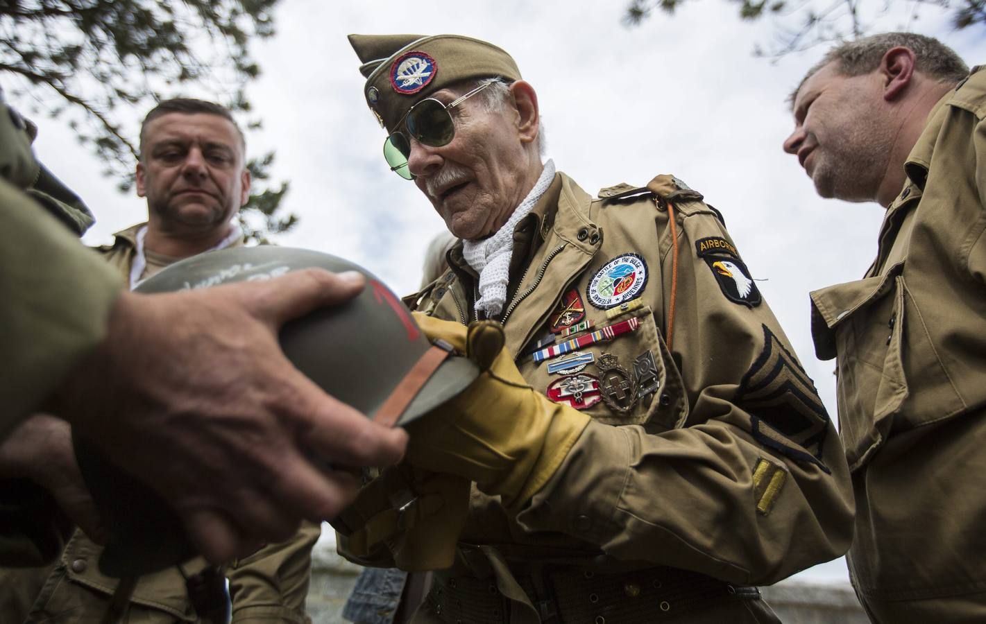 El veterano belga de la Segunda Guerra Mundial George Michels, quien voluntariamente se unió al 326th Airborne estadounidense, firma autógrafos en el cementerio de Colleville-Sur-Mer.