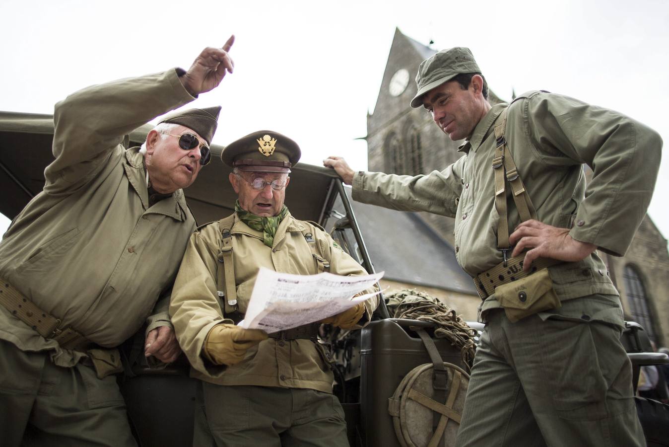 Varios entusiastas franceses de la Segunda Guerra Mundial, con uniformes réplica de los de la Segunda Guerra Mundial, se reúnen frente a la iglesia de Sainte-Mere-Eglise.