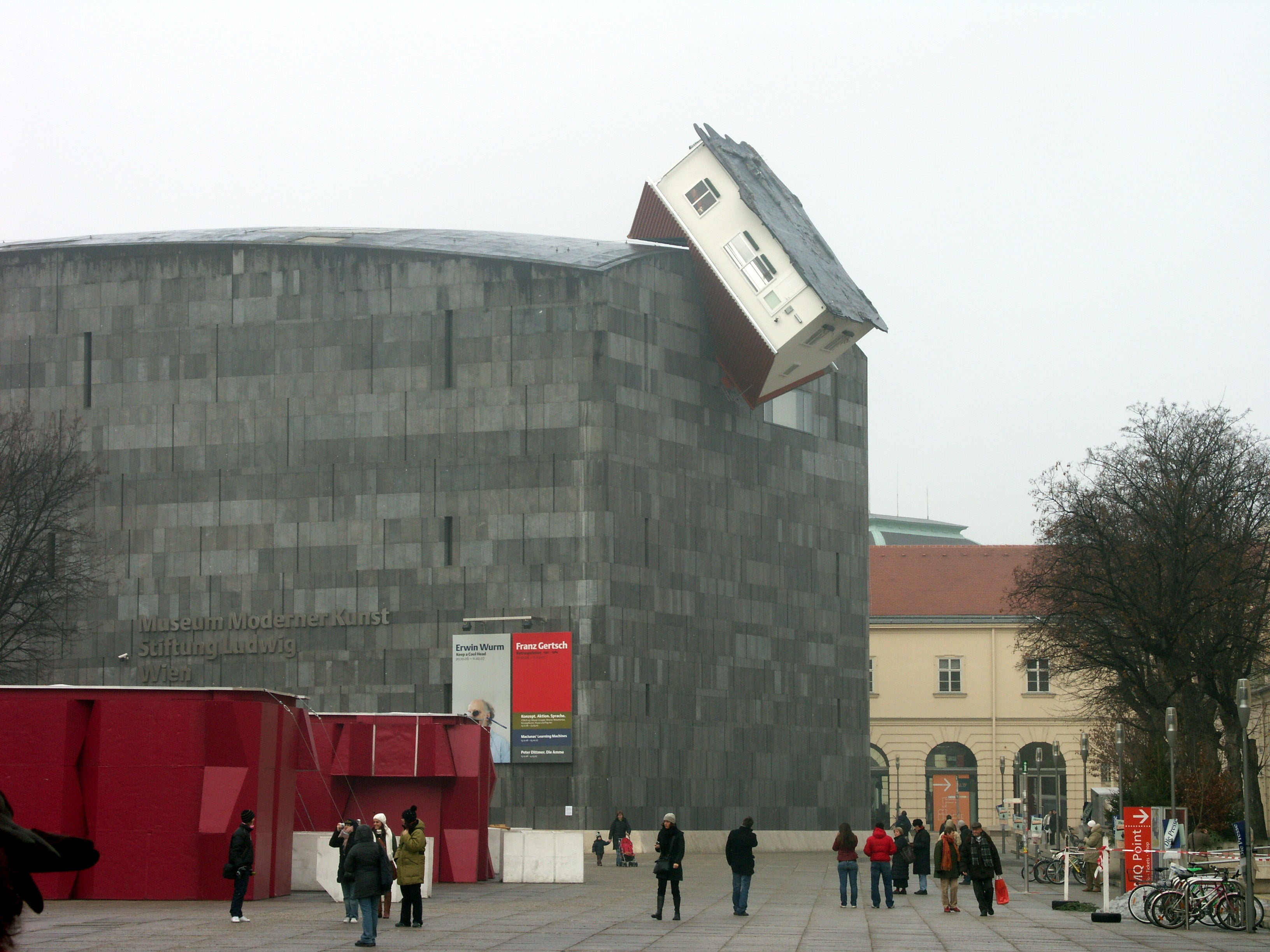 Ataque de casa. MUMOK (Museo Moderner Kunst) es el museo de arte más grande de Austria. El artista Erwin Wurm incrustó una casa en el edificio.