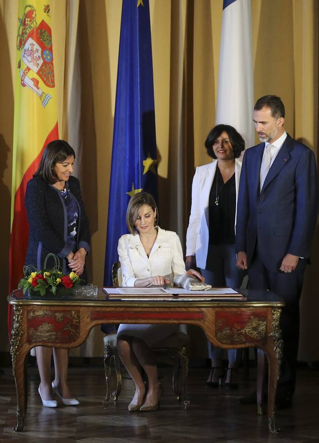 La reina Letizia firma el libro de honor en presencia del rey Felipe VI y la alcaldesa de París, Anne Hidalgo.