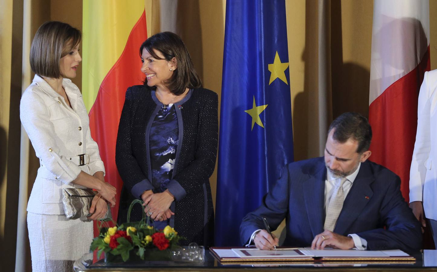 El rey Felipe VI firma el libro de honor en presencia de la reina Letizia y la alcaldesa de París, Anne Hidalgo.