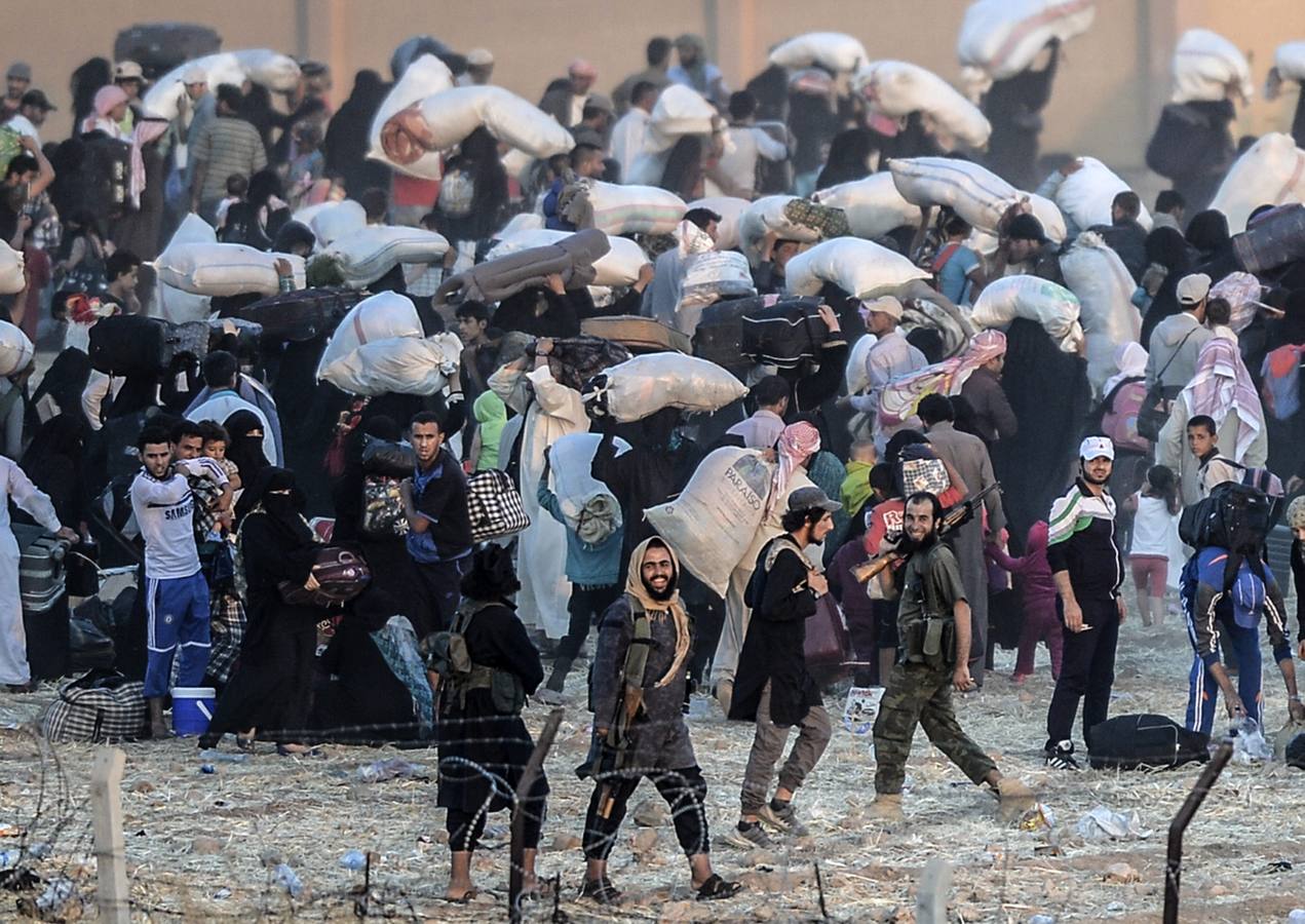 Fotografía de la serie ganadora del tercer premio en "Historias" de la categoría de noticias puntuales de la 59 edición del World Press Photo, tomada por el fotógrafo turco Bulent Kilic. La fotografía muestra a varias familias sirias intentando cruzar ilegalmente la frontera turca cerca de la ciudad de Akçakale (Turquía) el 14 de junio de 2015.