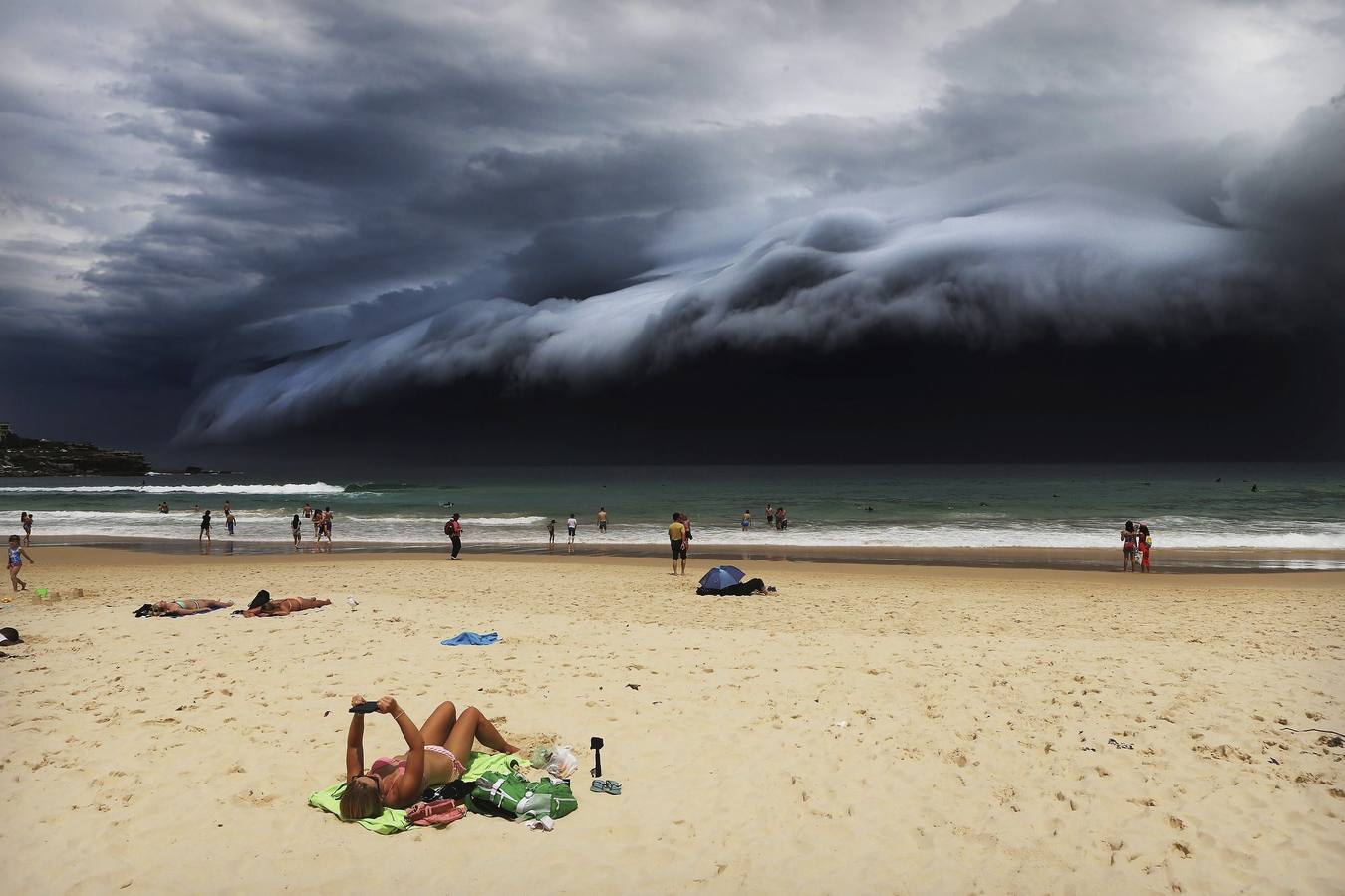 Imágen captada por el fotógrafo australiano Rohan Kelly para el diario Daily Telegraph galardonada con el primer premio Nature (Naturaleza), en la categoría individual. La foto muestra a una turista leyendo mientras un cielo tormentoso se cierne sobre la playa de Bondi Beach, en Sídney, Australia, el 6 de noviembre de 2015.