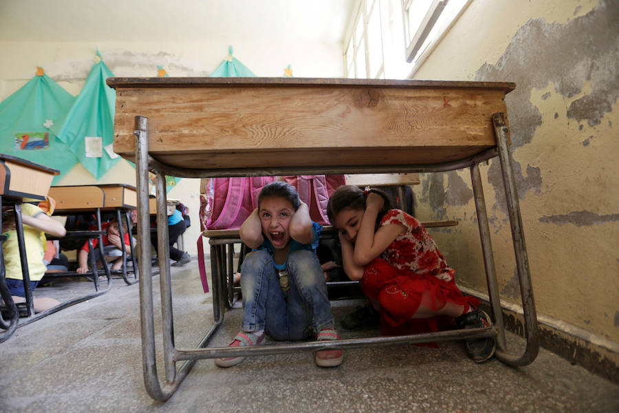 Niños asisten a una clase de conciencia de seguridad de guerra llevada a cabo por los miembros de la defensa civil, en la zona controlada por los rebeldes de la ciudad Maaret al-Numan, en la provincia de Idlib (Siria).