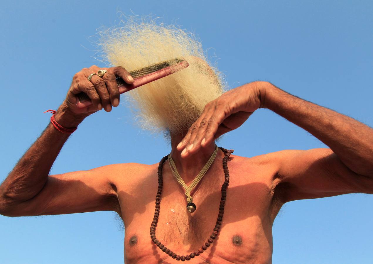 Un hombre santo hindú, o sadhu, peina su barba después de tomar un baño en las aguas del río Shipra durante la tradicional peregrinación del Kumbhmela en Ujjain (la India).