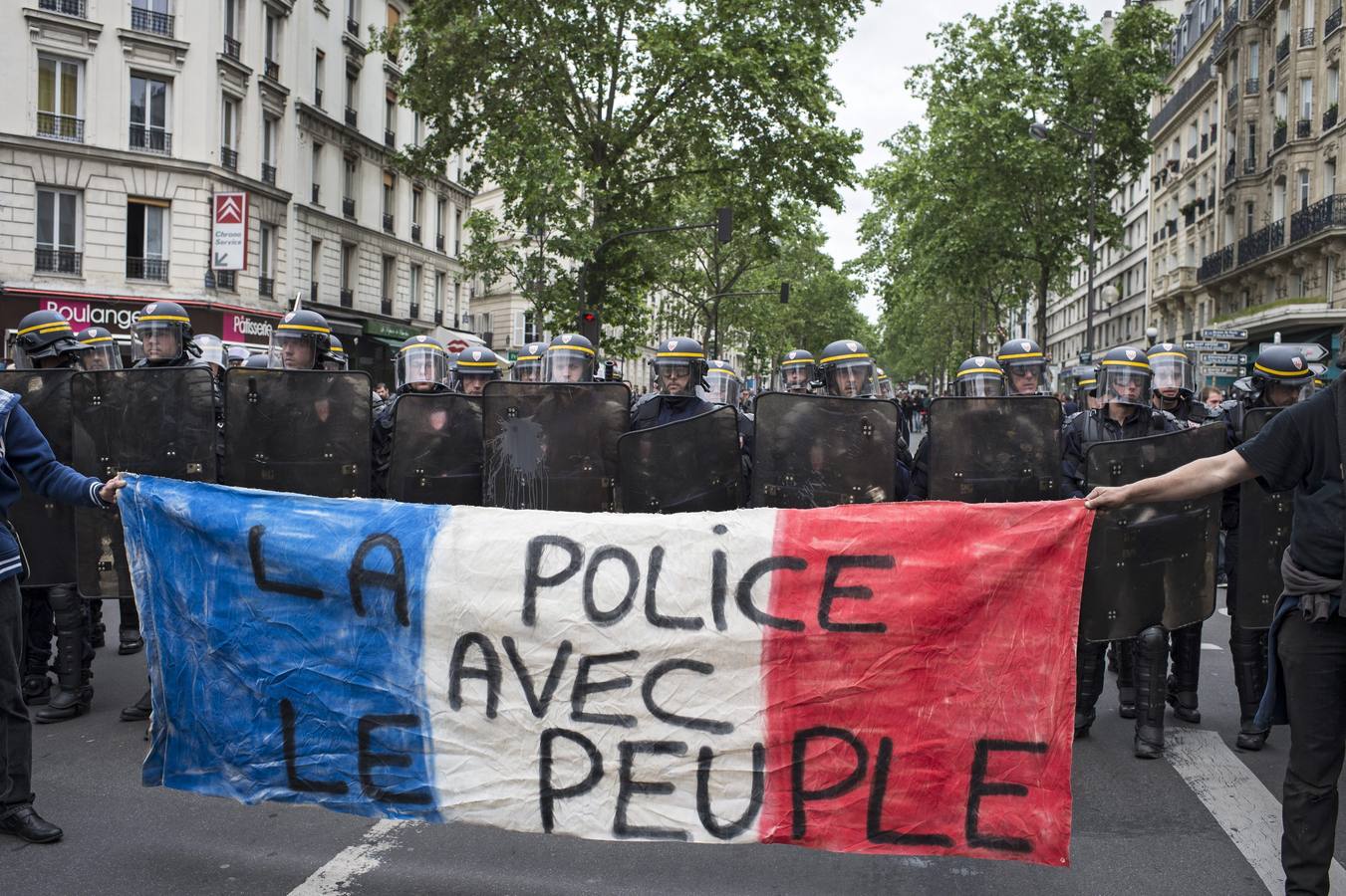 Varios manifestantes muestran una pancarta en la que se lee "la policía con el pueblo" ("The police with the People") durante una protesta celebrada en París, Francia hoy, 26 de mayo de 2016. El primer ministro francés, Manuel Valls, cargó hoy contra los organizadores de las protestas contra su reforma laboral, consideró "inaceptable" que bloqueen centros petroleros y puertos para agotar el carburante en las gasolineras, y les acusó de "atacar los intereses económicos de Francia".