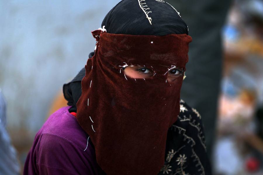 Una mujer iraquí que huyó de la violencia en su pueblo de Saqlaguiya, al noroeste de Faluya, espera a recibir alimentos y ayuda en un punto militar.