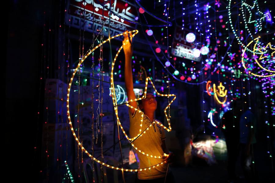 Un palestino decora su tienda con luces de colores en la ciudad vieja de Jerusalén.