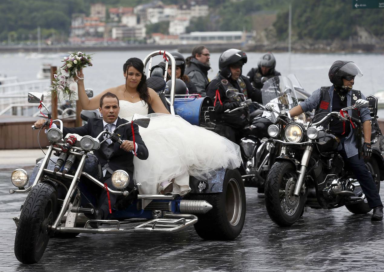 Una pareja de novios "moteros", seguidos de sus invitados en la parte vieja de la capital donostirarra, tras contraer matrimonio hoy en el Ayuntamiento de San Sebastián.EFE/Javier Etxezarreta