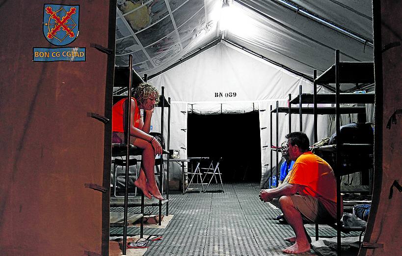 Los voluntarios descansan en las literas de la tienda de campaña.