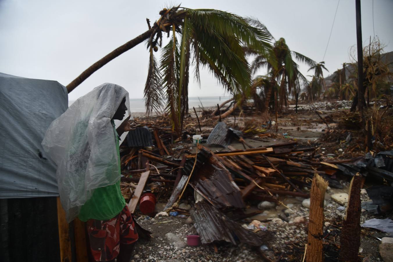 James, víctima del huracán Matthew, ante los restos de su casa en Los Cayos (Haití). / AFP PHOTO / HÉCTOR RETAMAL