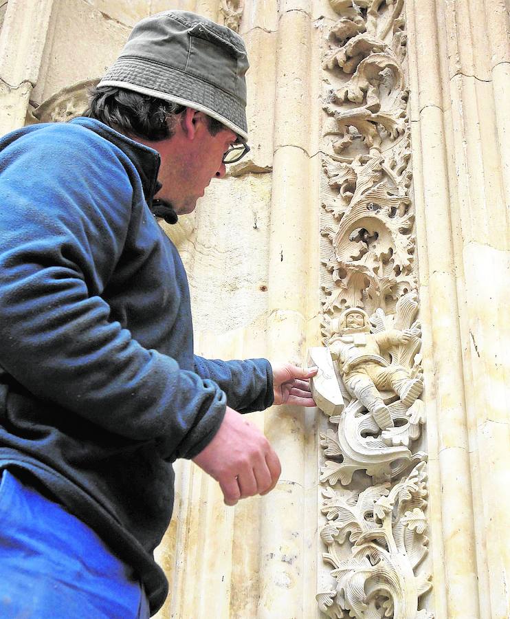 Altos vuelos.. Un cantero se aplica en la restauración de un brazo del astronauta de la portalada de la catedral nueva de Salamanca.