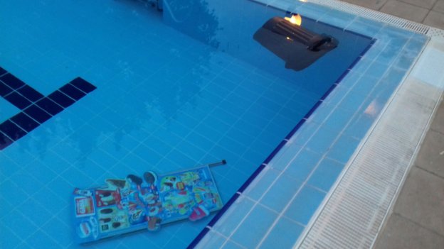 Un cartel de helados y una papelera, en el fondo de la piscina de Burjassot. 
