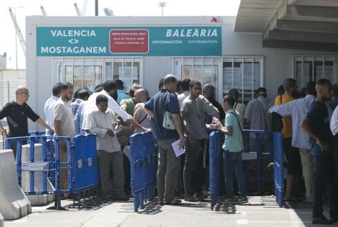 Viajeros aguardan para comprar un billete en el puerto. 