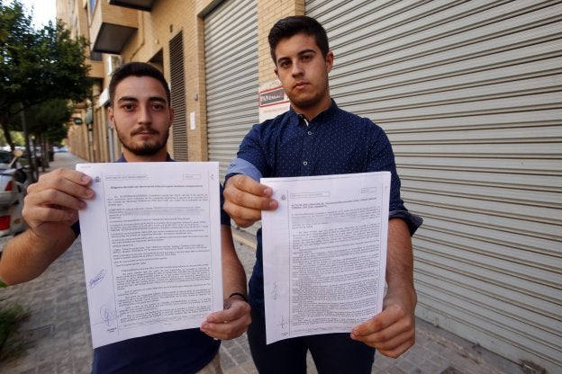 Roberto y Edgar muestran las denuncias por agresión presentadas ante la Guardia Civil, ayer, en Valencia. 