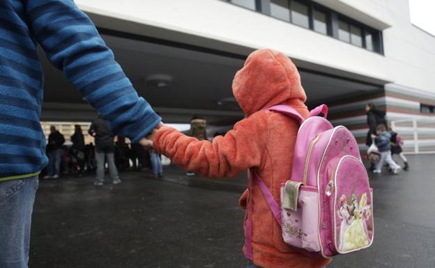 Una niña entra en un centro escolar. 