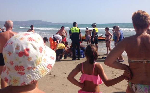 Las fuerzas de seguridad intentas reanimar al anciano en la playa del Pinar de Castellón.