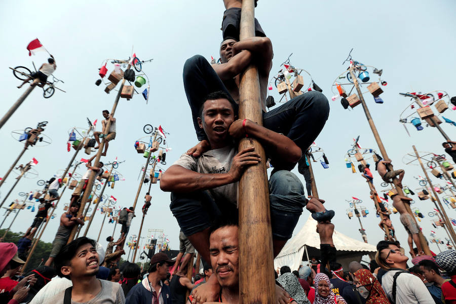 Tailanda celebra su Día de la Independencia de una manera muy peculiar: colocan en vertical los troncos talados de nogales que engrasan con aceite para dificultar la llegada a la cima en la que se encuentran varios premios. 