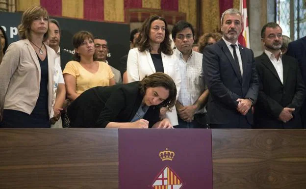 La alcaldesa de Barcelona, Ada Colau, firmando en el libro de condolencias.