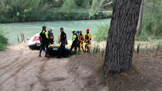Dos equipos de rescate, ayer, en la orilla del río Cabriel. 