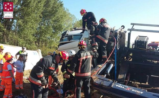 Bomberos rescatando al conductor atrapado.